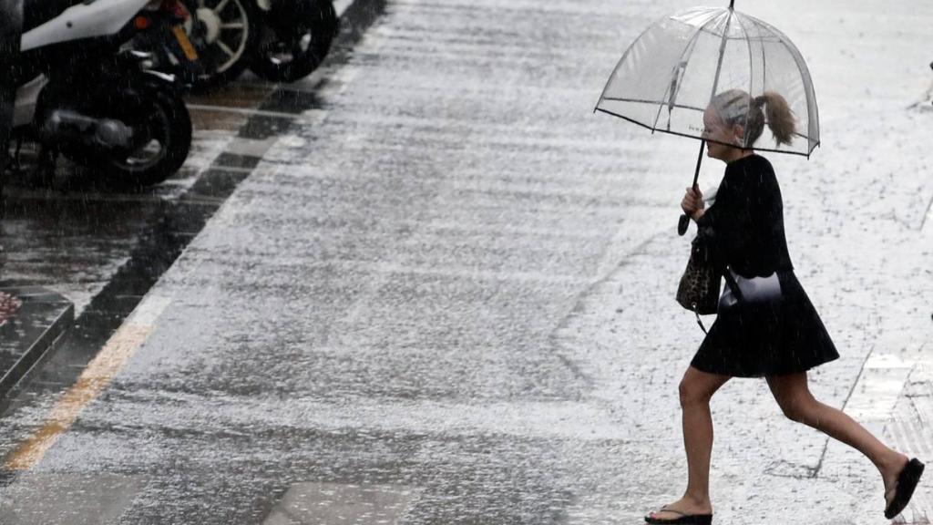 Uan mujer sostiene un paraguas mientras llueve.
