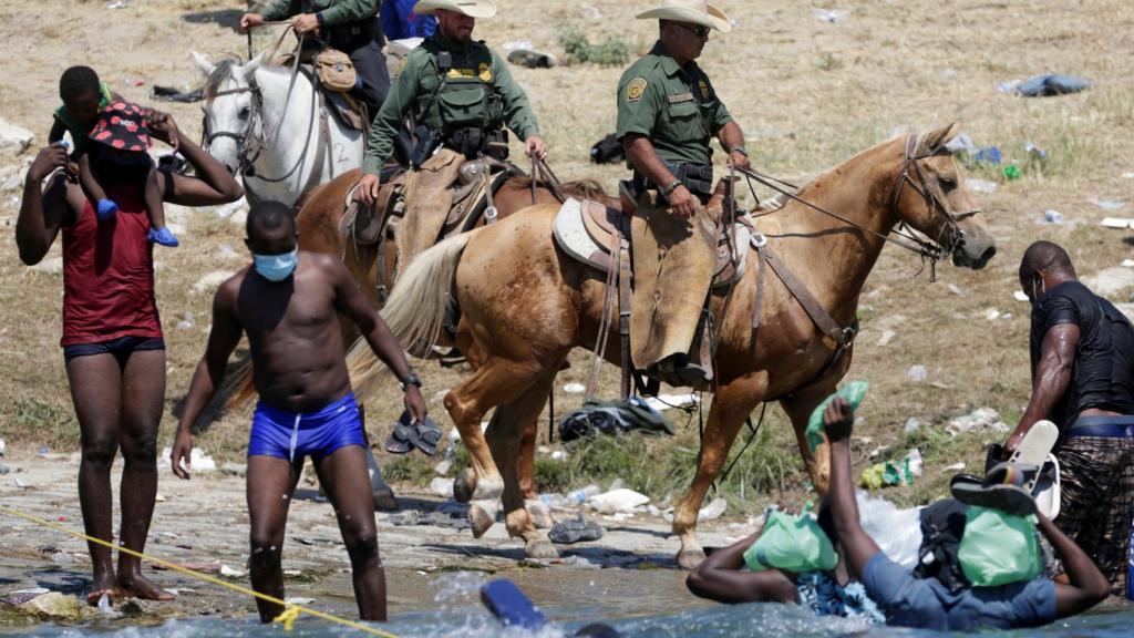 Agentes de la Patrulla Fronteriza vigilando a migrantes en Río Bravo.