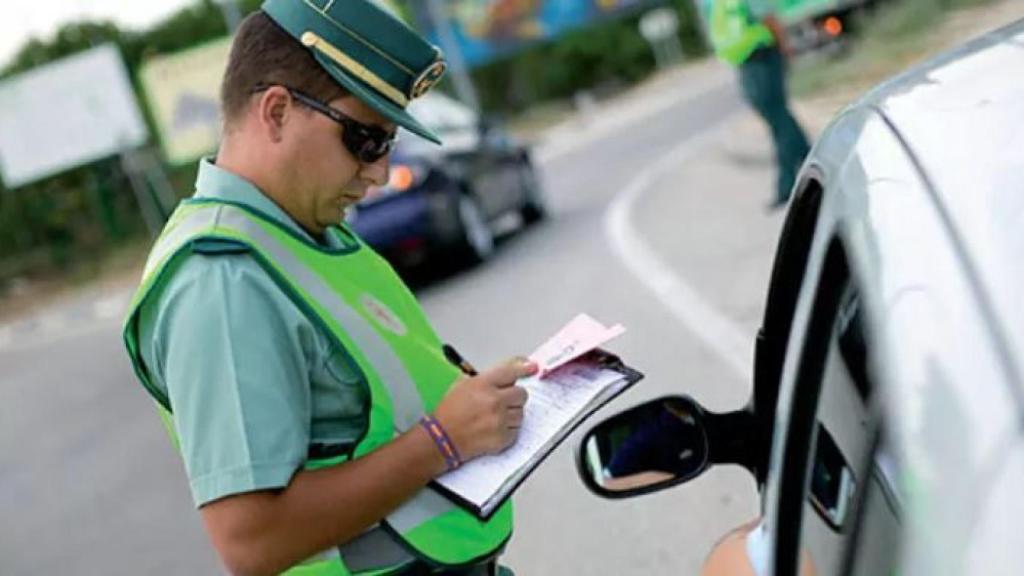 Un guardia civil pone una multa de tráfico.
