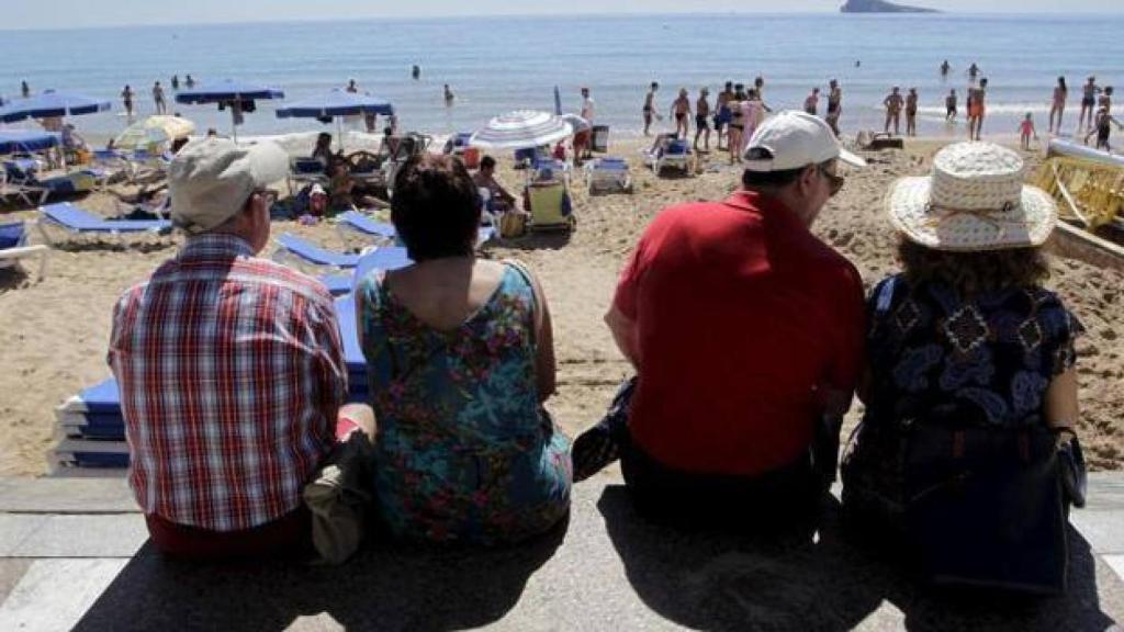 Dos parejas de jubilados en la playa de Levante de Benidorm, en imagen de archivo.