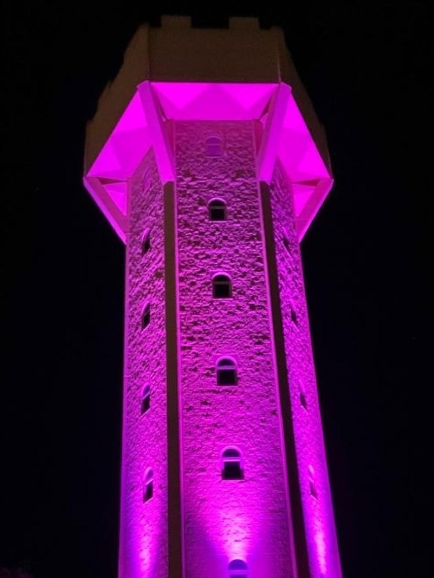 Depósito del agua de Arcenillas iluminado de púrpura