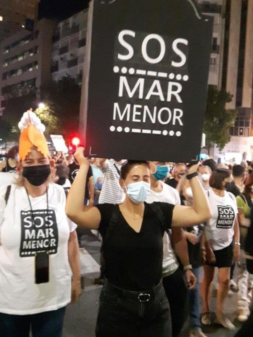 Una joven manifestándose con una lápida por el Mar Menor.