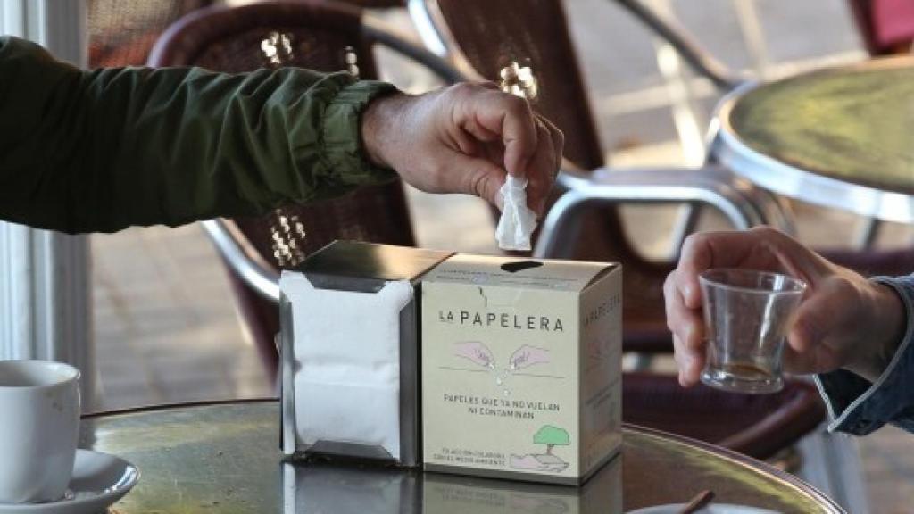 La mesa de la terraza de un bar con un servilletero con servilletas que no limpian.