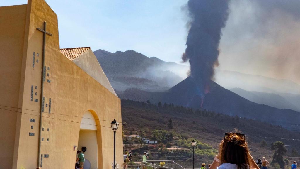 Una señor a observa el derrumbe del Cumbre Vieja desde la distancia.