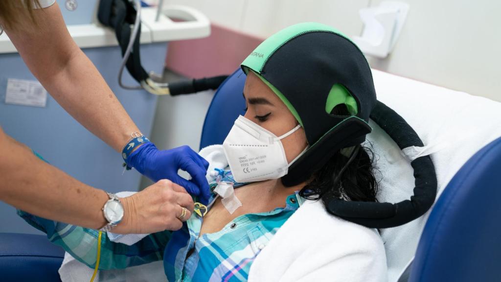 Una paciente de cáncer de mama recibe quimioterapia con un gorro de frío para evitar la alopecia.