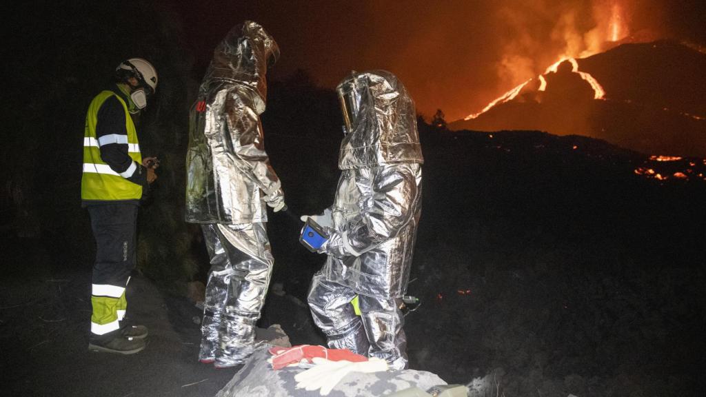 Los especialistas que visitan la erupción volcánica cada noche vestidos de astronautas.