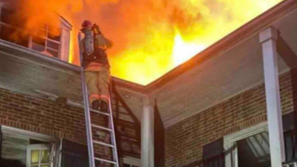 Un bombero rescatando a uno de los chicos atrapado.