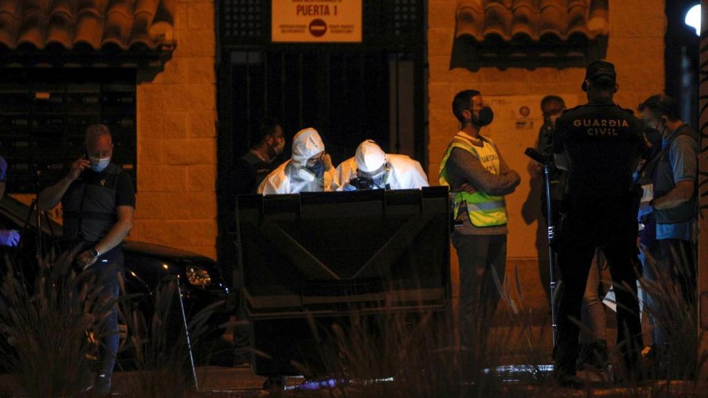 Los investigadores examinando los restos en la basura.