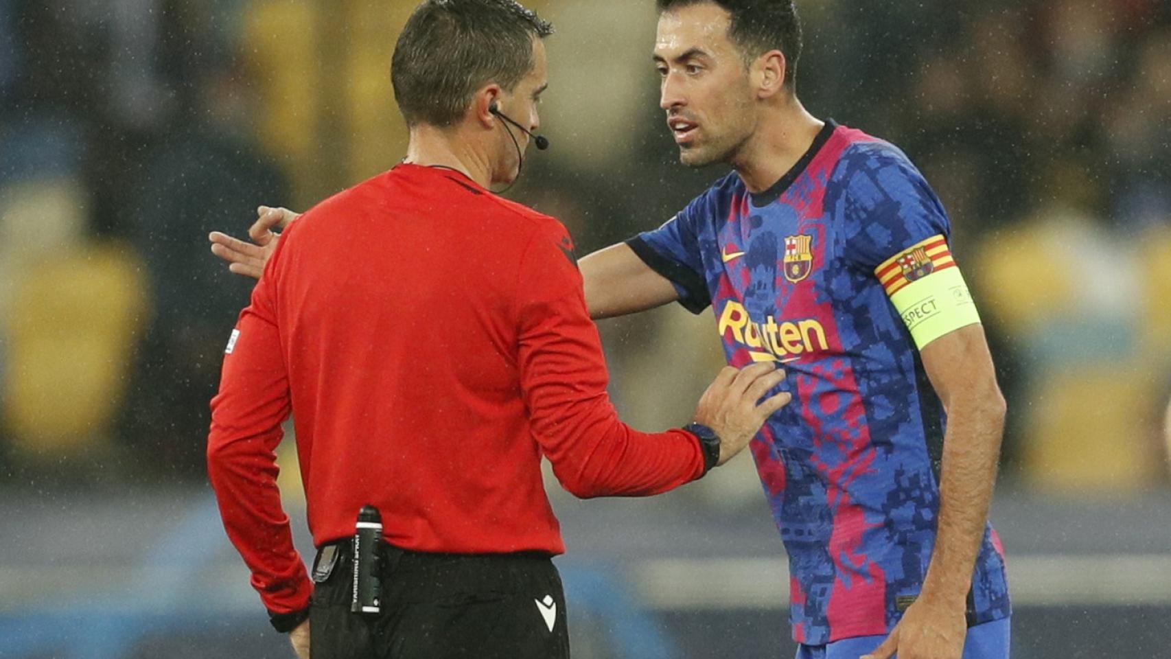 Sergio Busquets protesta una decisión a Ovidiu Hategan