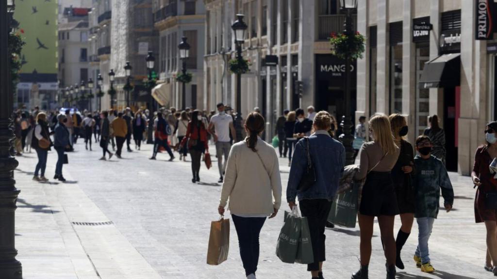 Una imagen de archivo de unos viandantes caminando por calle Larios tras hacer unas compras.