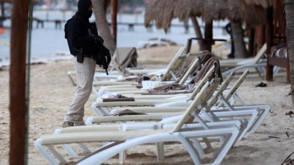 Un agente de la policía de México en la playa del Caribe donde se ha producido el tiroteo.
