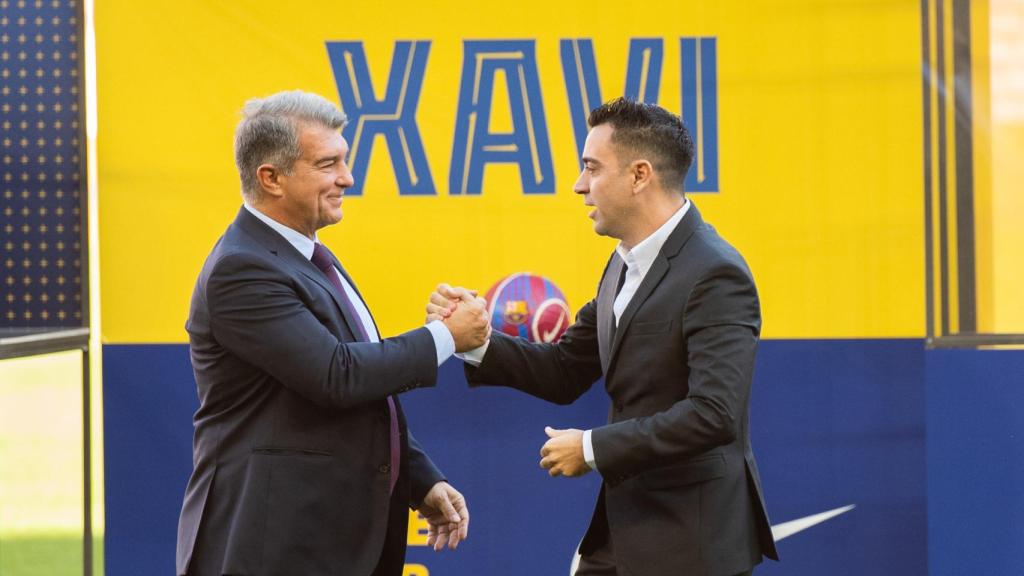 Apretón de manos entre Laporta y Xavi Hernández