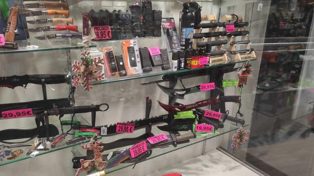 Tásers junto a machetes en el expositor de una tienda.