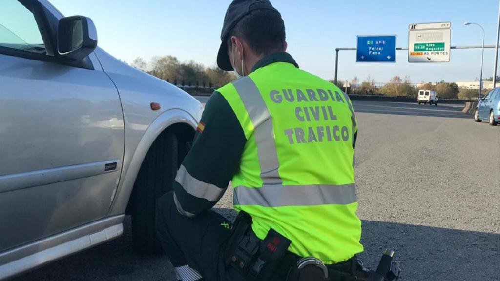 Un agente comprueba los neumáticos de un vehículo durante un control, en una foto de archivo.