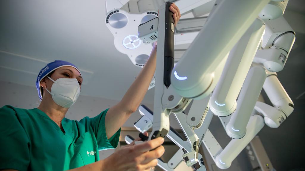Personal de la unidad de cirugía robótica preparando los brazos del robot Da Vinci para una operación.
