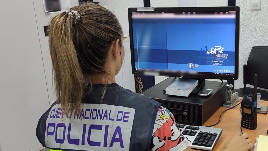 Una agente de la Policía Nacional investigando en un ordenador.