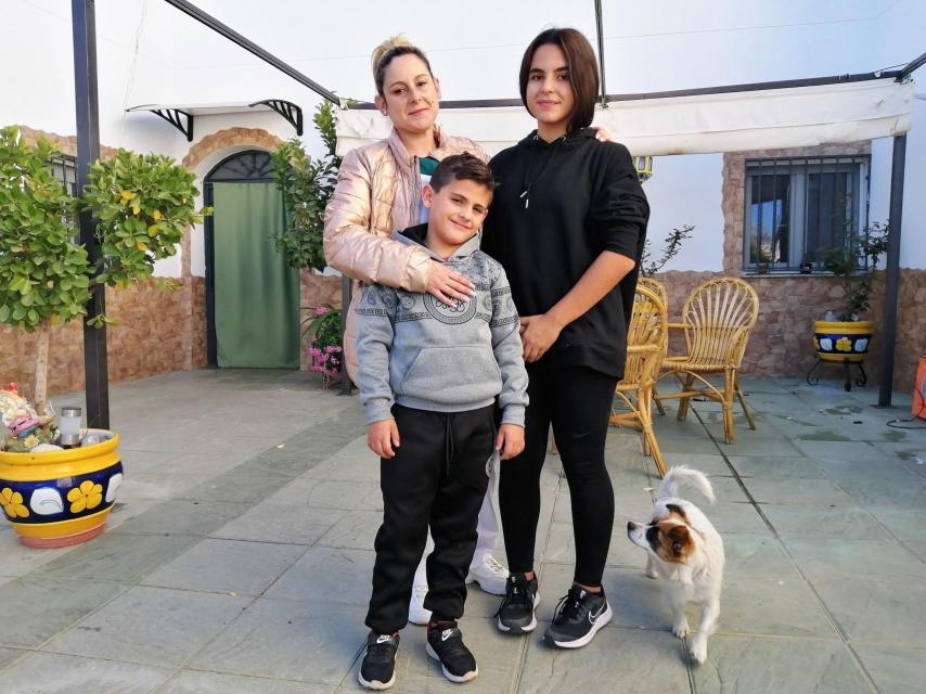 Vanesa Morillas y sus hijos, Patricia y Sergio,  posan en el patio de su casa cueva en Paulenca (Guadix).