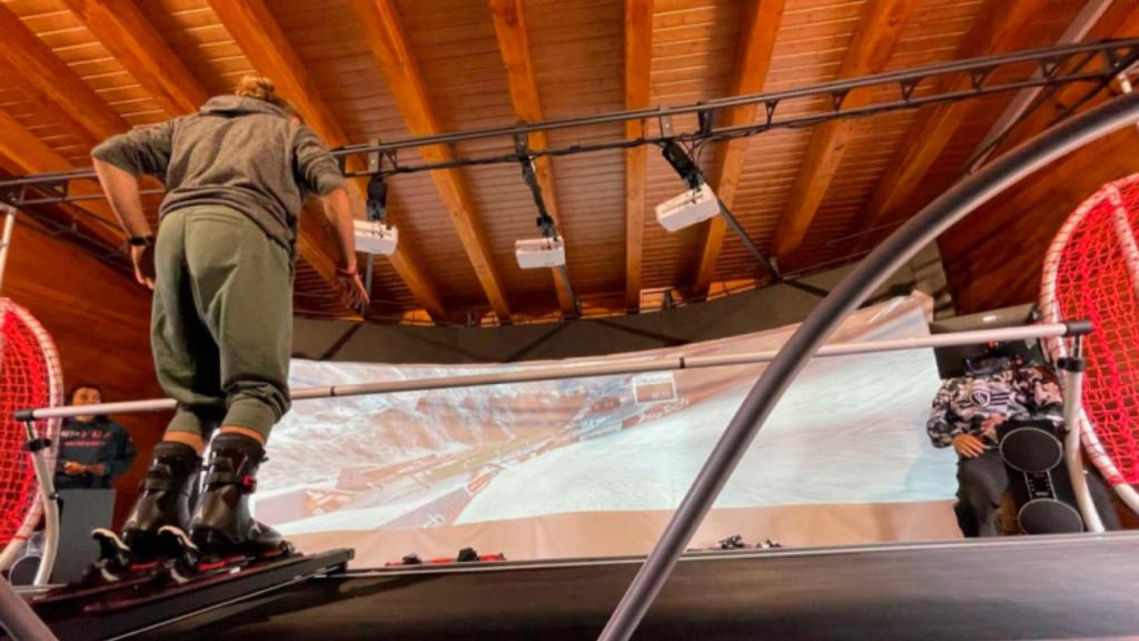 Una persona usando el simulador con esquis.