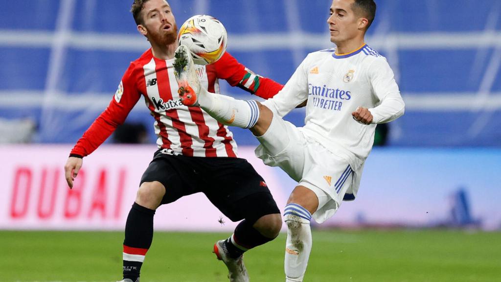 Iker Muniain y Lucas Vázquez disputan un balón dividido