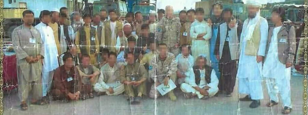 Foto impresa en la que aparece Hasan, que trabajaba en la base, junto a soldados españoles.