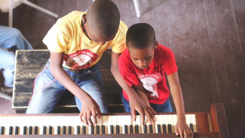 Dos niños haitianos tocando el piano.
