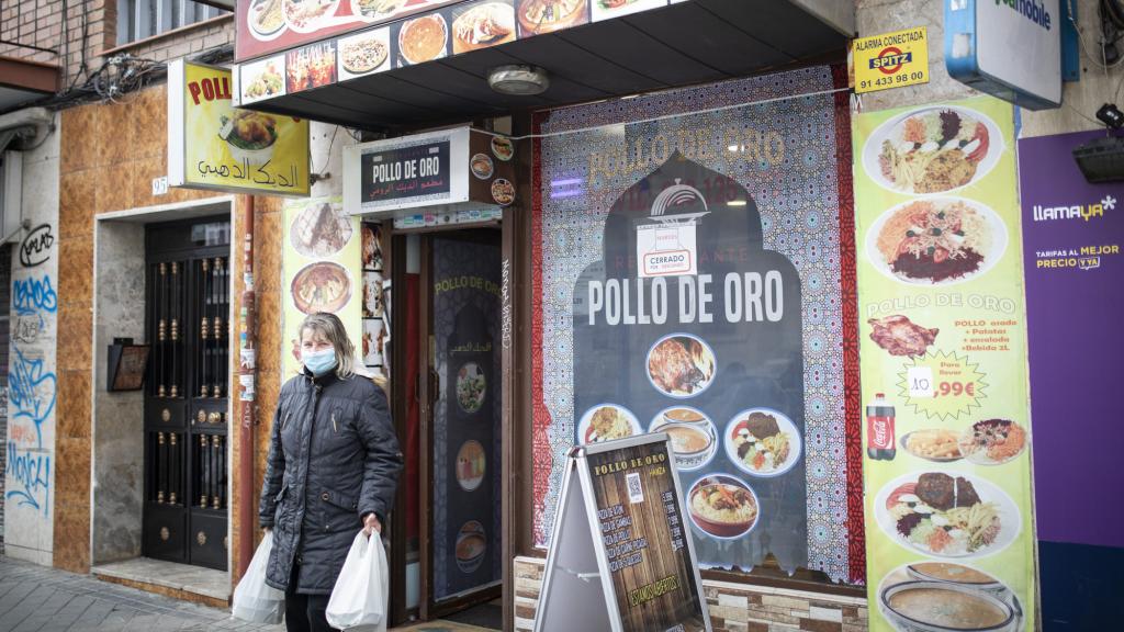 Una clienta sale de El Pollo de Oro con la comida que acaba de comprar.