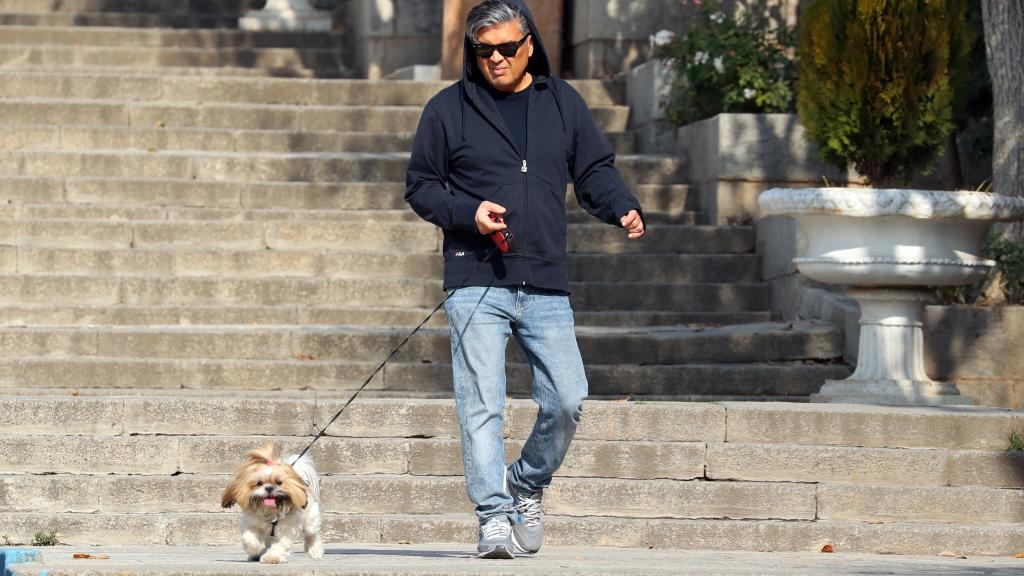 Un hombre pasea a su perro en las callas de Teherán.