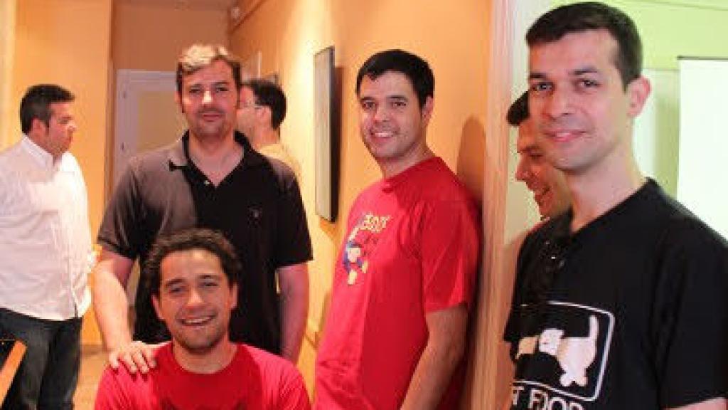 Luis Hernández, de rojo y en pie, apoyado contra la pared