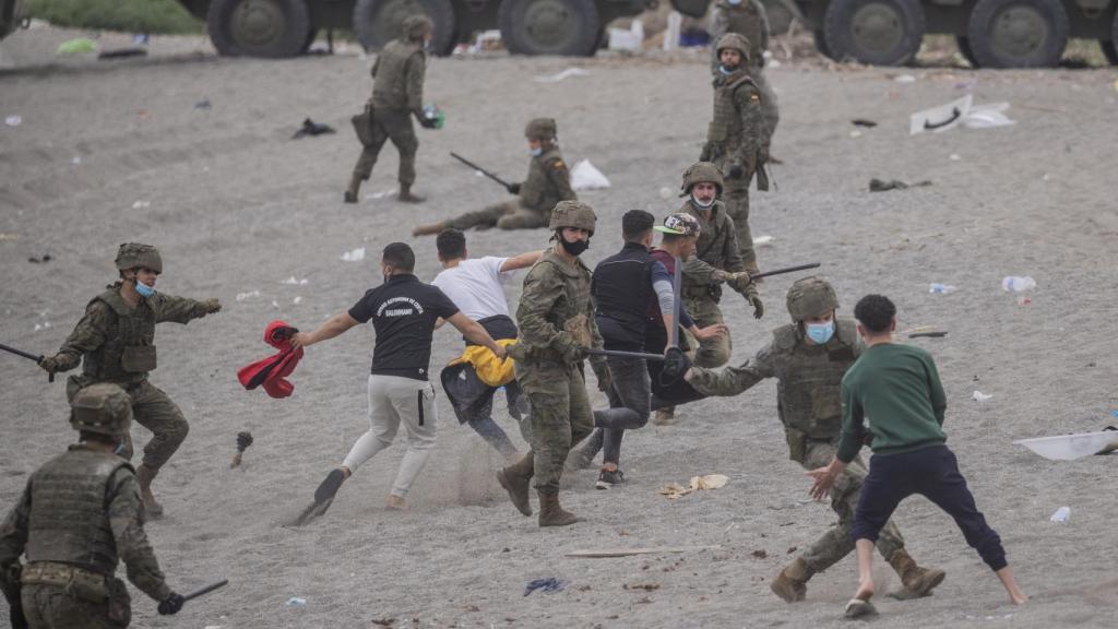Militares españoles tratan de contener a inmigrantes marroquíes en la playa de El Tarajal el pasado mayo.