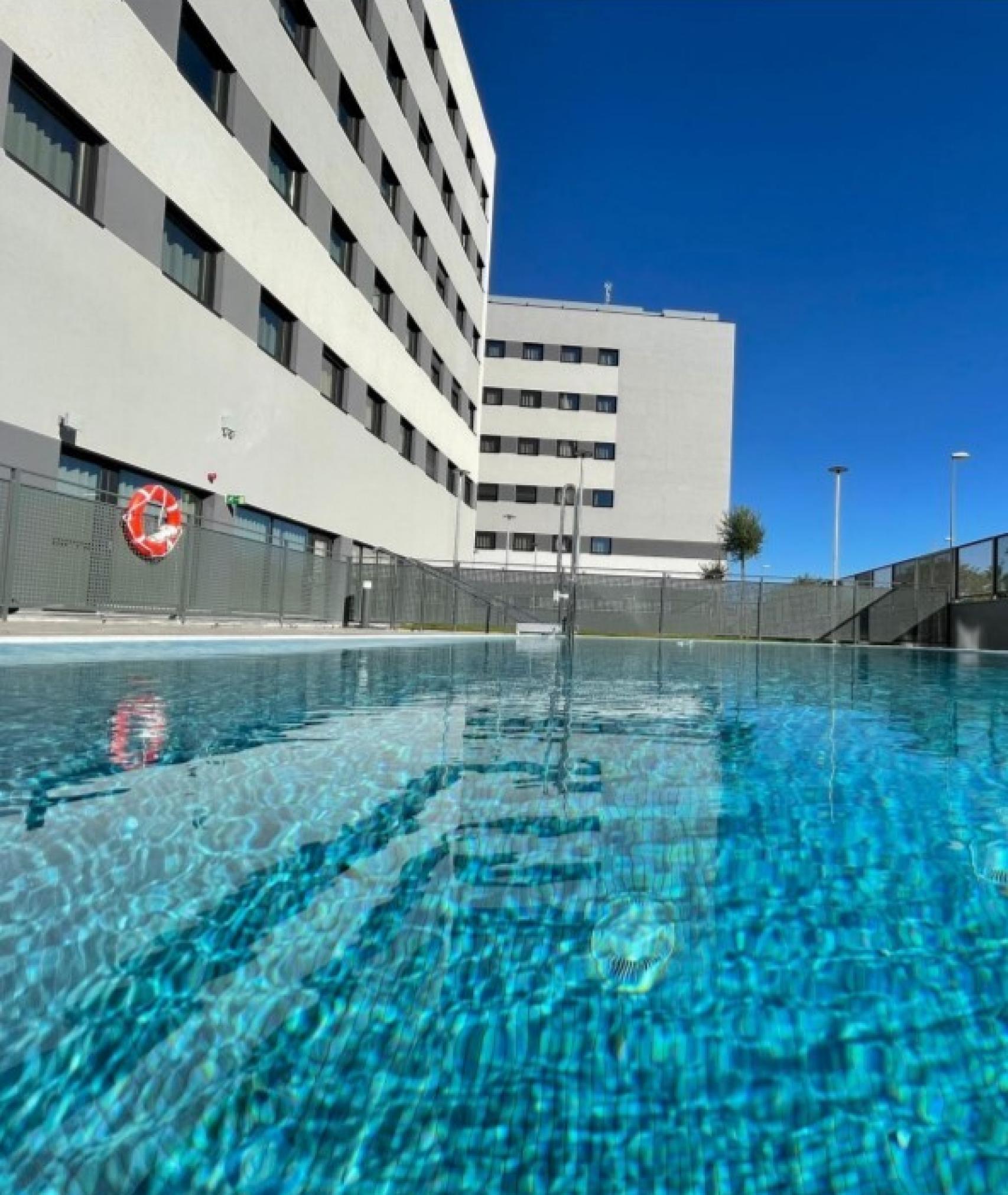 Vista de la piscina y de los edificios que componen el complejo.