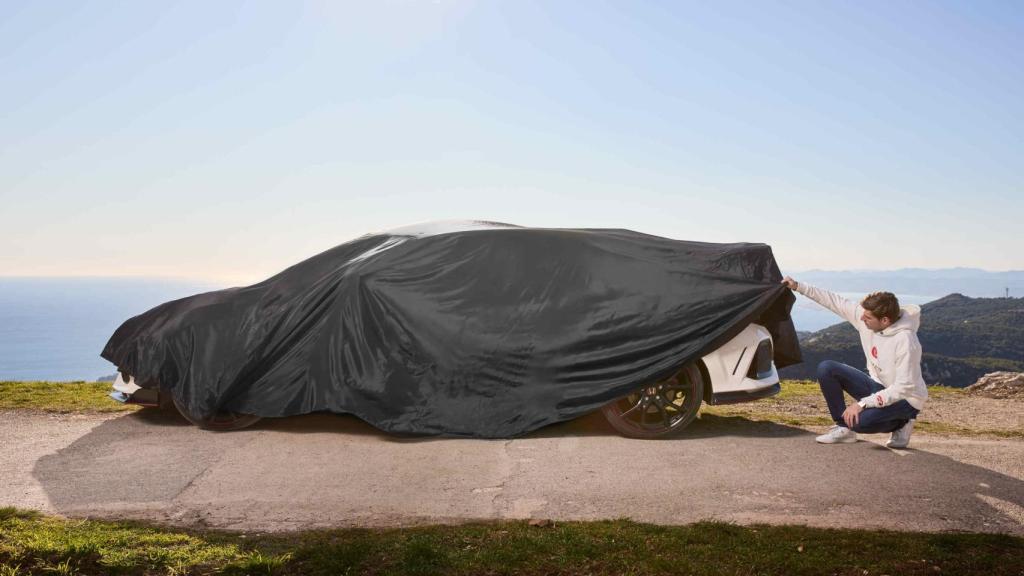 Max Verstappen junto a su coche de calle tapado con una lona.