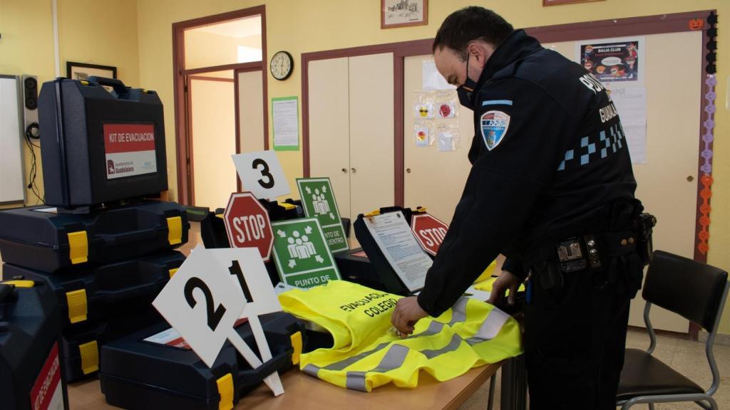 Un policía de Guadalajara junto a los maletines de evacuación.