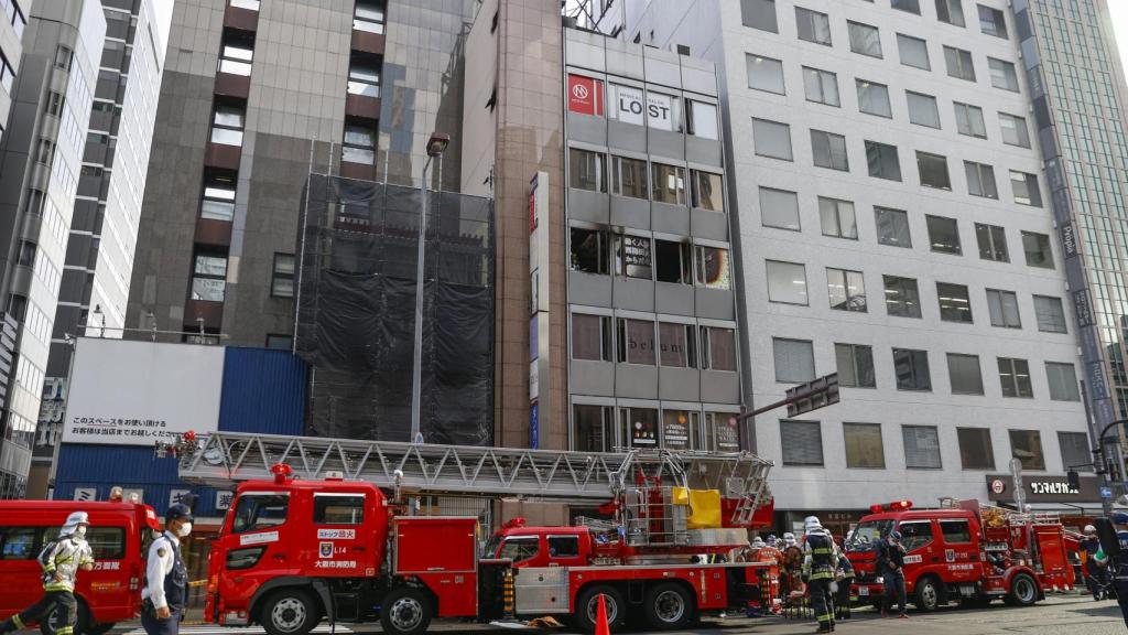 Los bomberos junto al edificio en el que ocurrió el incendio.