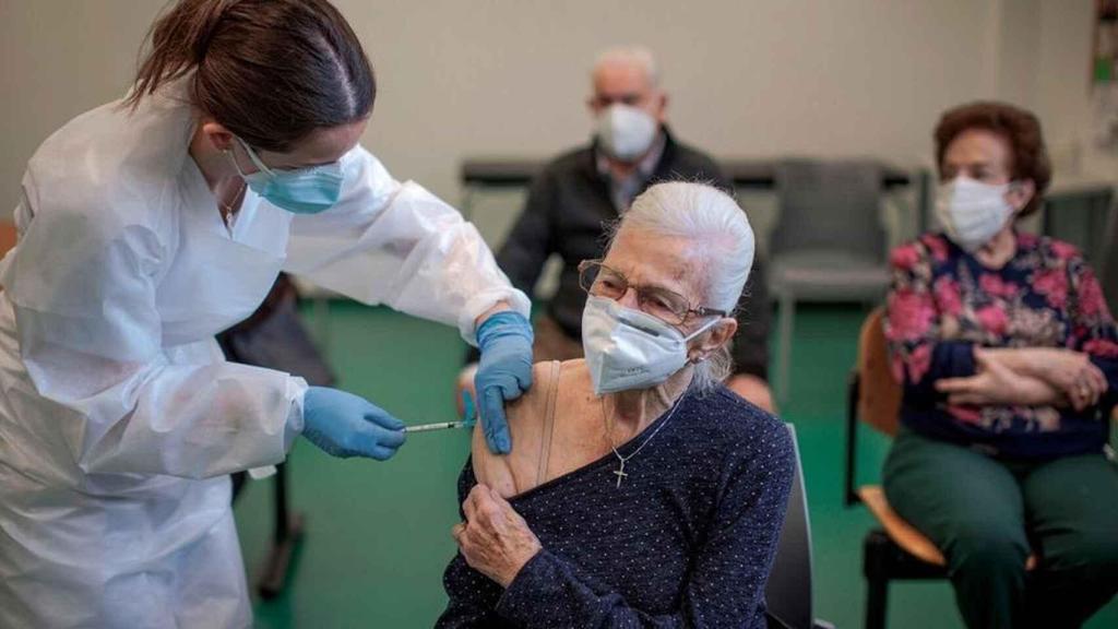 Una persona de una residencia es vacunada por una sanitaria.