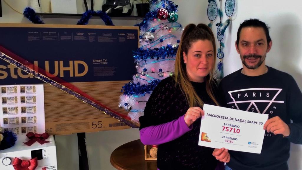 Celia y Dani, los organizadores del sorteo, con el número premiado.