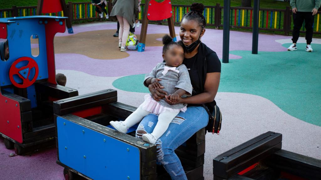 Una mujer con su hija en un parque de Burela.