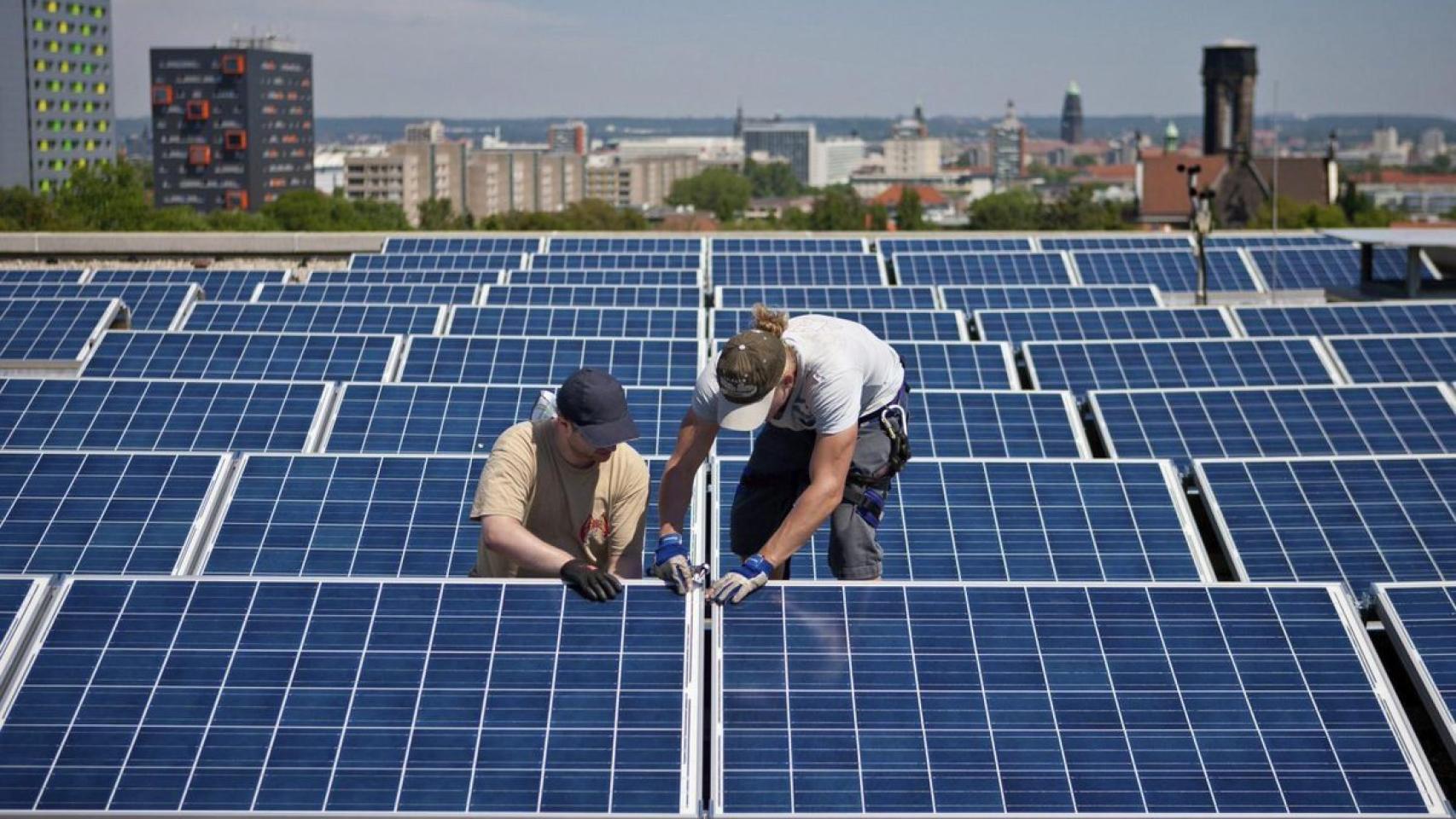 Dos operarios instalan placas solares.