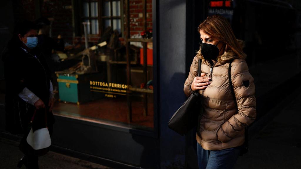 Una mujer con mascarilla pasea por las calles de Roma, Italia.