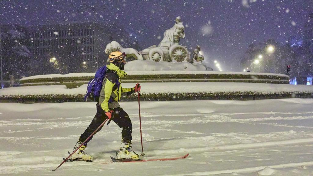 Una persona avanza con esquíes junto a la fuente de Cibeles, cubierta de nieve por la borrasca Filomena, en Madrid (España) a 9 de enero de 2021.