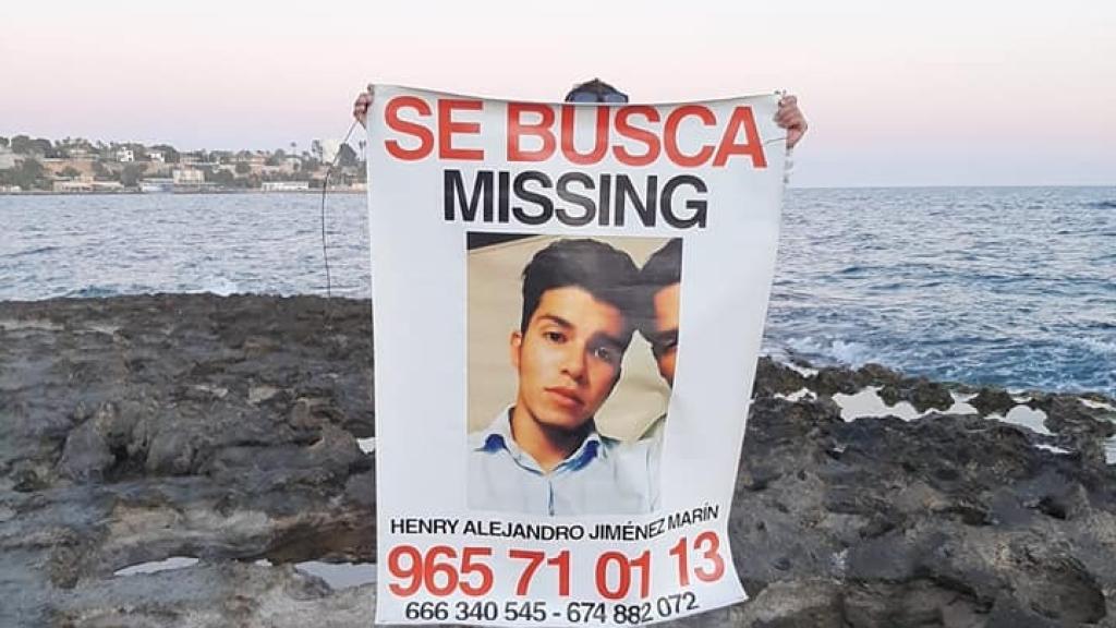 Una persona sostiene un cartel del desaparecido Henry.