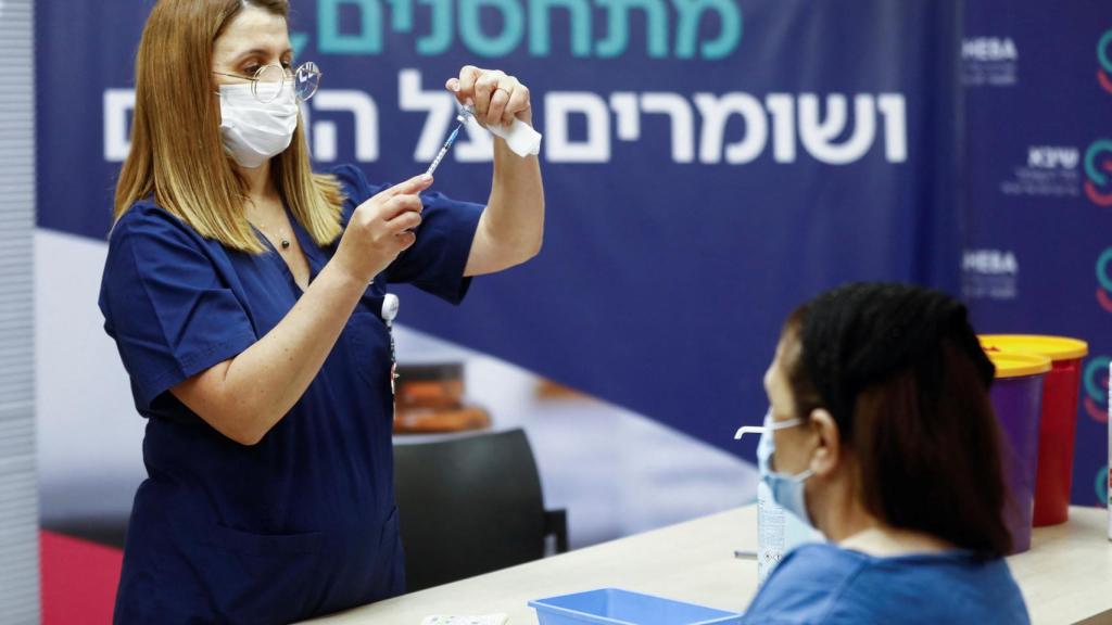 Una sanitaria se prepara para vacunar.