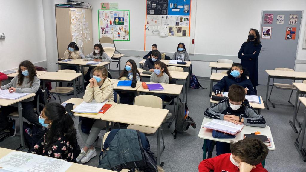 Imagen de un aula con menores con mascarila.