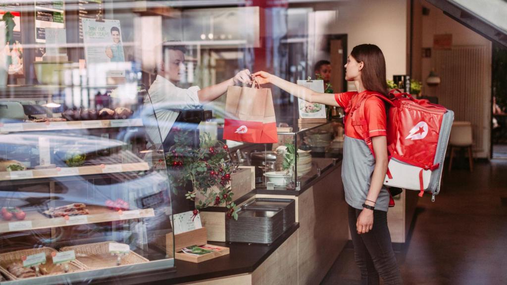 Una repartidora de Delivery Hero recogiendo la comida en un restaurante.