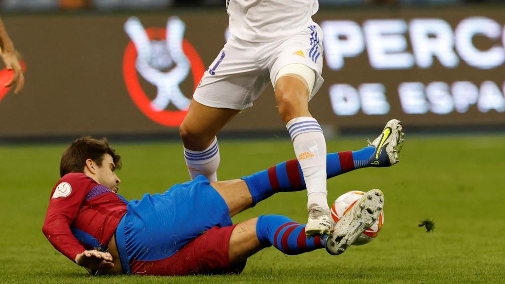 Gerard Piqué intentando recuperar el balón ante Asensio