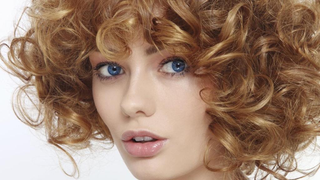 Una modelo luciendo su cabello ondulado y rizado.