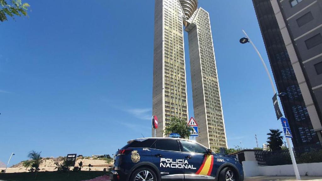 Un coche de Policía pasa por el edificio Intempo en Benidorm.