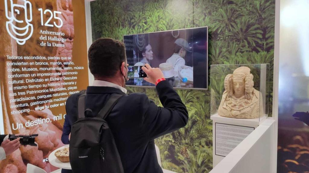 Un visitante hace una foto con el móvil al stand de Elche.