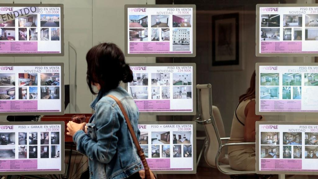 Una joven pasa por delante de una inmobiliaria en Valencia, en imagen de archivo.