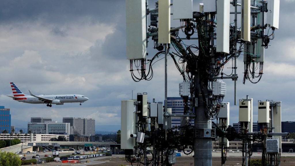 Un avión aterrizando en el aeropuerto de California junto a una antena