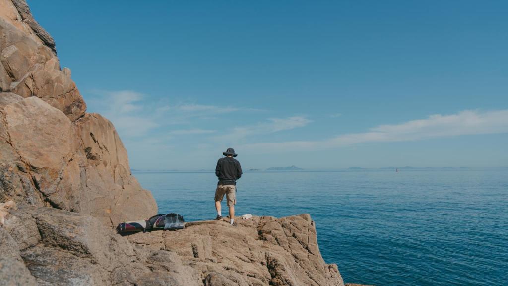 Un hombre pescando en un acantilado.